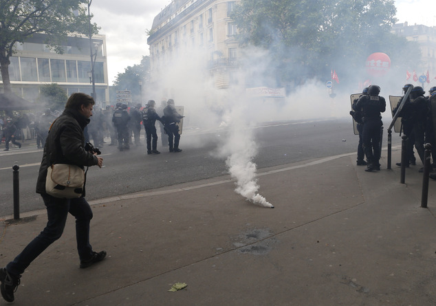 A man walks past a gas canister during a demonstration in Paris Tuesday, June 14, 2016. Street protests are planned across France, rail workers and taxi drivers are going on strike and the Eiffel Tower is due to be closed as part of a protest against a reform aimed at loosening the country's labor rules. (AP Photo/Francois Mori)