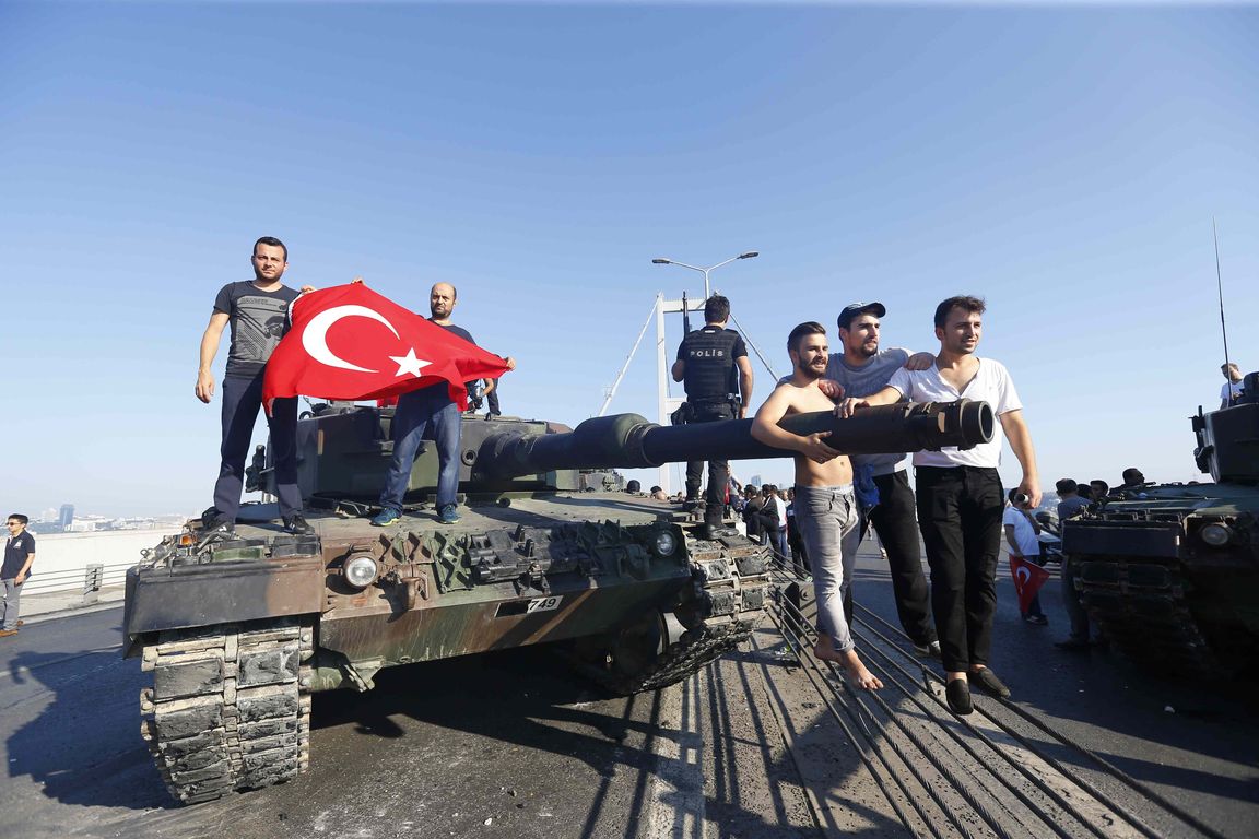 People pose near a tank after troops involved in the coup surrendered on the Bosphorus Bridge in Istanbul, Turkey July 16, 2016. REUTERS/Murad Sezer