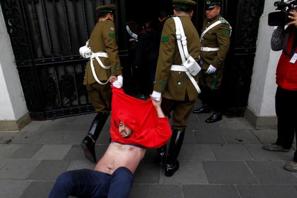 Police guards take out a demonstrator during a protest inside the government house against the government's education reform in Santiago, Chile, May 24, 2016. REUTERS/Stringer