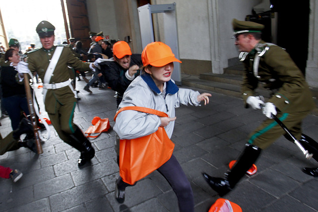 Students try to run past presidential guards before getting detained for trespassing inside La Moneda presidential palace in Santiago, Chile, Tuesday, May 24, 2016. The students, who demand the right to free education, were protesting the education policies under President Michelle Bachelet's government. (Marcelo Hernandez/Aton via AP) NO PUBLICAR EN CHILE - CHILE OUT