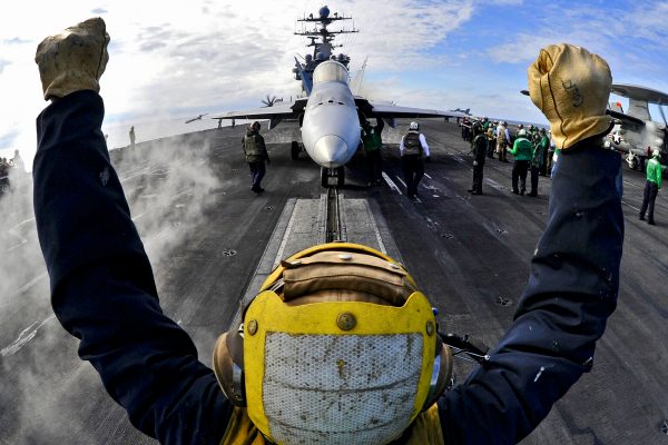 110201-N-6003P-225 ATLANTIC OCEAN (Feb. 1, 2011) An aircraft director guides an F/A-18C Hornet onto a catapult aboard the aircraft carrier USS Harry S. Truman (CVN 75). Harry S. Truman is supporting fleet replacement squadron carrier qualifications. (U.S. Navy photo by Mass Communication Specialist 2nd Class Kilho Park/Released)