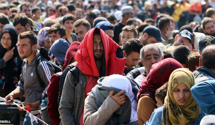 Migrants and refugees  waiting for buses after crossing  the border between Hungary and Austria in Nickelsdorf, Austria  70 kilometers (43 miles) southeast of Vienna, Sunday, Sept. 13, 2015. (AP Photo/Ronald Zak)