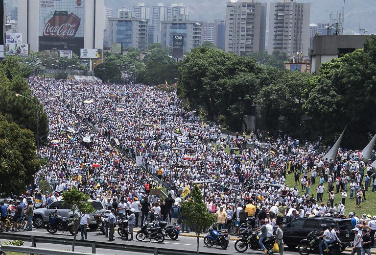 View of a mass march against Venezuelan President Nicolas Maduro, in Caracas on April 19, 2017.  Venezuelans took to the streets Wednesday for massive demonstrations for and against President Nicolas Maduro, whose push to tighten his grip on power has triggered deadly unrest that has escalated the country's political and economic crisis. / AFP PHOTO / CARLOS BECERRA