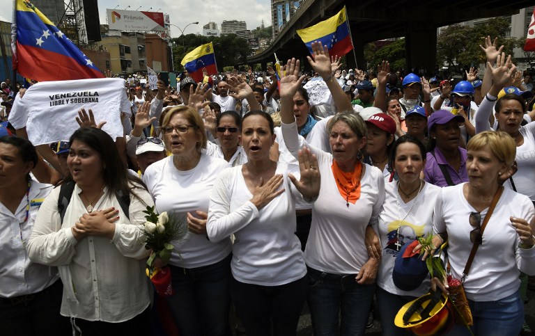 Venezuelan opposition ex-congresswoman Maria Corina Machado (C) takes part in a women's march aimed to keep pressure on President Nicolas Maduro, whose authority is being increasingly challenged by protests and deadly unrest, in Caracas on May 6, 2017.
The death toll since April, when the protests intensified after Maduro's administration and the courts stepped up efforts to undermine the opposition, is at least 36 according to prosecutors.
 / AFP PHOTO / JUAN BARRETO