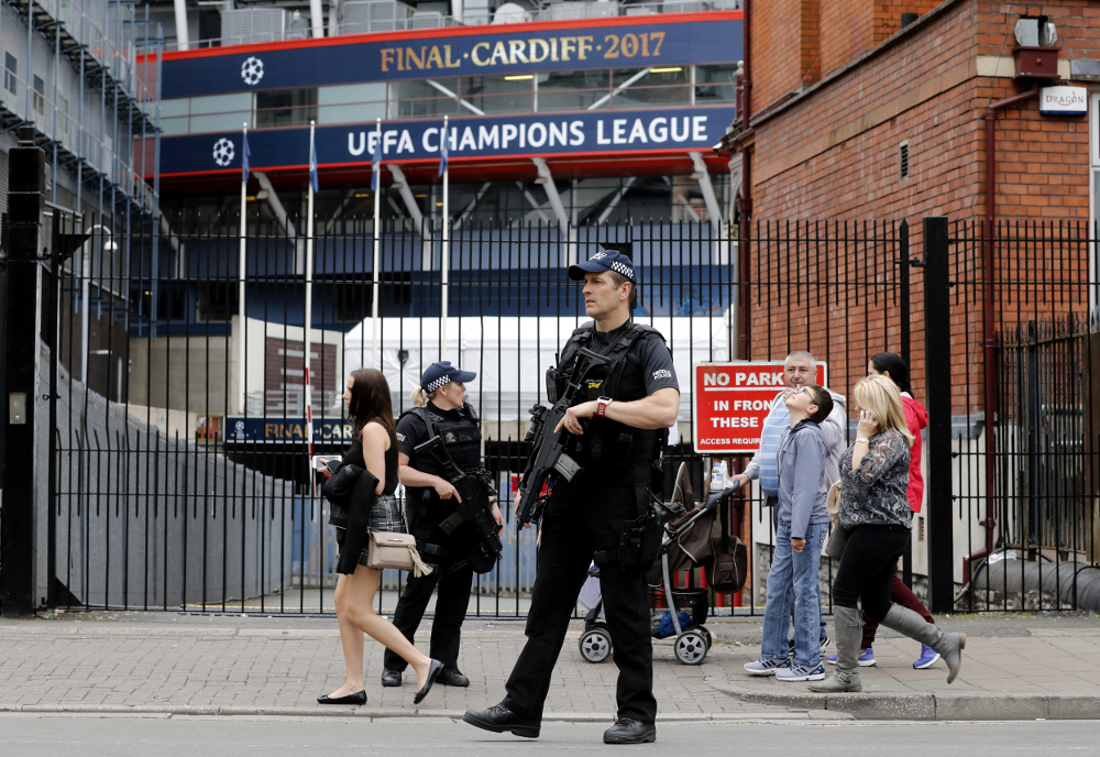 Armed police officers stand guard outside the Millennium Stadium in Cardiff, Wales, Friday June 2, 2017, ahead of Champions League soccer team training sessions. Real Madrid will play Juventus in the final of the Champions League soccer match in Cardiff on Saturday. (AP Photo/Frank Augstein)