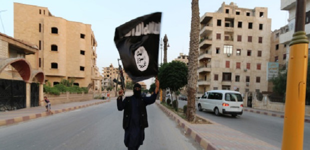 A member loyal to the Islamic State in Iraq and the Levant (ISIL) waves an ISIL flag in Raqqa June 29, 2014. The offshoot of al Qaeda which has captured swathes of territory in Iraq and Syria has declared itself an Islamic "Caliphate" and called on factions worldwide to pledge their allegiance, a statement posted on jihadist websites said on Sunday. The group, previously known as the Islamic State in Iraq and the Levant (ISIL), also known as ISIS, has renamed itself "Islamic State" and proclaimed its leader Abu Bakr al-Baghadi as "Caliph" - the head of the state, the statement said. REUTERS/Stringer (SYRIA - Tags: POLITICS CIVIL UNREST )  BEST QUALITY AVAILABLE