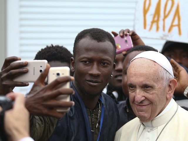 Pope Francis poses for a selfie with a man as he visits a migrant reception centre during a pastoral visit in Bologna, on October 1, 2017.  / AFP PHOTO / POOL / ALESSANDRO BIANCHI        (Photo credit should read ALESSANDRO BIANCHI/AFP/Getty Images)