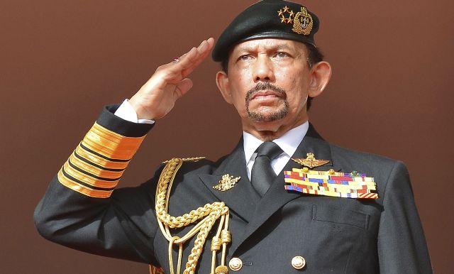 Brunei's Sultan Hassanal Bolkiah salutes as the national anthem is played during celebrations for Brunei's 30th National Day, in Bandar Seri Begawan February 23, 2014. REUTERS/Ahim Rani (BRUNEI - Tags: POLITICS ANNIVERSARY) - RTX19CJ8