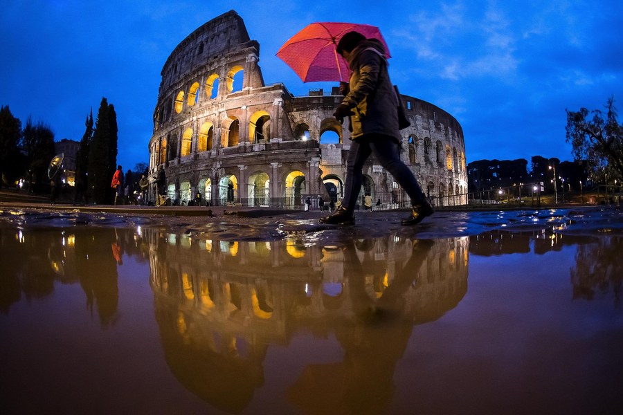 epa06407143 Tourists shelter from the rain under an umbrella near the Colosseum in Rome, Italy, 27 December 2017. A storm front is set to bring rain, wind and snow to Italy on 27 and 28 December, according to weather forecast. A wave of Arctic air will bring widespread rain to the centre and northeast, while snow will hit the north and winds will pick up everywhere, reports stated.  EPA/ANGELO CARCONI