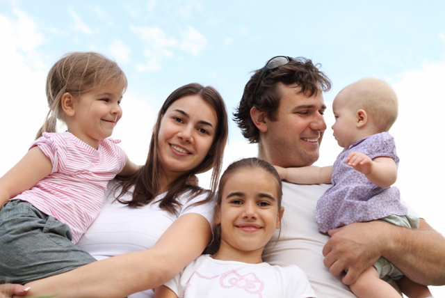 Happy young family with three daughters outdoors