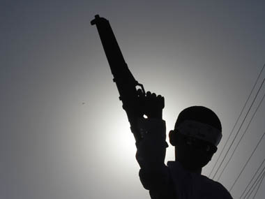 A boy is silhouetted against the sun as he holds a toy gun during a rally attended by some of nearly 3,000 supporters of an Islamist alliance Sunni Ittehad Council in Karahi October 22, 2011, against the sentence of convicted killer Mumtaz Qadri. A Pakistani court this month sentenced to death Qadri, the killer of Salman Taseer, the governor of Pakistan's largest province, after he had called for reform of a law against blasphemy, local media reported. REUTERS/Athar Hussain (PAKISTAN - Tags: POLITICS CIVIL UNREST CRIME LAW)