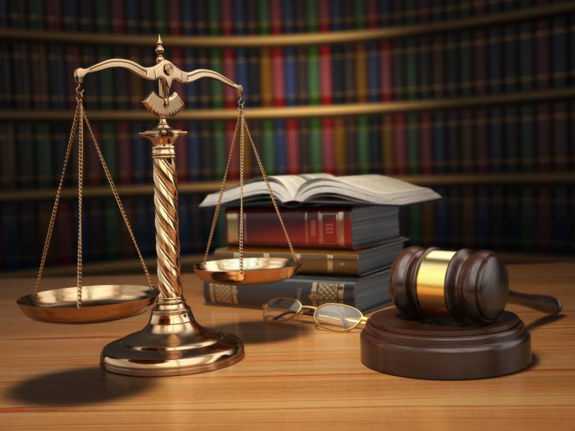 Justice concept. Gavel,  golden scales and books in the library with dof effect. 3d