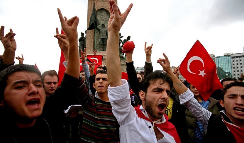 epa01152430 Turkish ultra nationalist party MHP supporters chant slogans and make 'Gray Wolf' signs against terror, at Taksim Square in Istanbul, Turkey on 21 October 2007. After Turkey has stationed thousands of troops on the border with Iraq, at least 12 Turkish soldiers have been killed in clashes with Kurdish rebels near the border, Turkish Tv NTV said.  EPA/TOLGA BOZOGLU