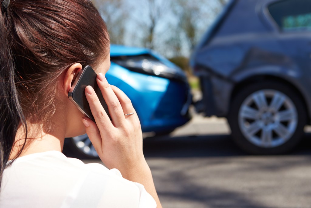 Female Driver Making Phone Call After Traffic Accident explaining what happend