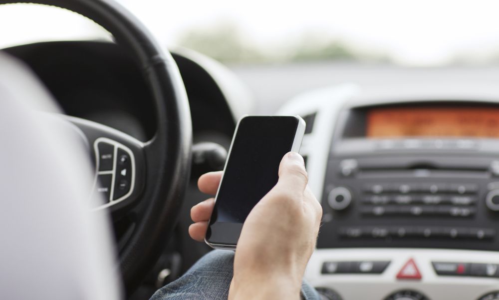 transportation and vehicle concept - man using phone while driving the car