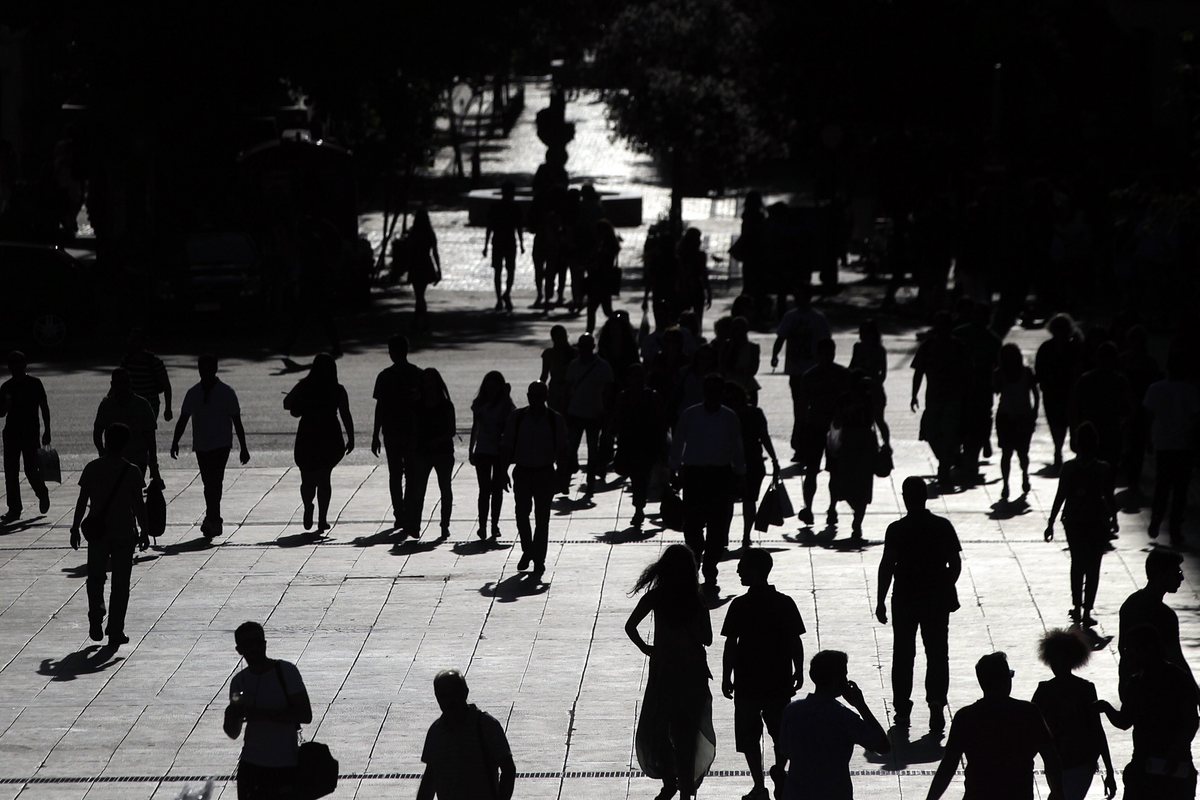 epa04816951 People walk in central Syntagma (Constitution) square, in front of the Finance Ministry and the Parliament building, in Athens, 24 June 2015. Greek Prime Minister Alexis Tsipras is set to conduct yet another round of crisis talks with representatives of the country's creditors, ahead of a crucial meeting of eurozone finance ministers where all sides hope a solution can be found to save the country from bankruptcy.  EPA/PANTELIS SAITAS