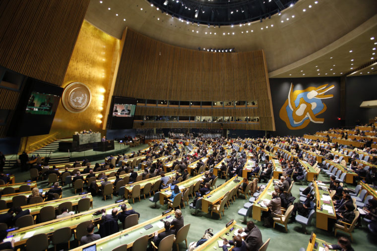 People gather at the General Assembly, prior to a vote, Thursday, Dec. 21, 2017, at United Nations headquarters.  President Donald Trump's threat to cut off U.S. funding to countries that oppose his decision to recognize Jerusalem as Israel's capital has raised the stakes in Thursday's U.N. vote and sparked criticism of his tactics, with one Muslim group calling it bullying or blackmail. (AP Photo/Mark Lennihan)