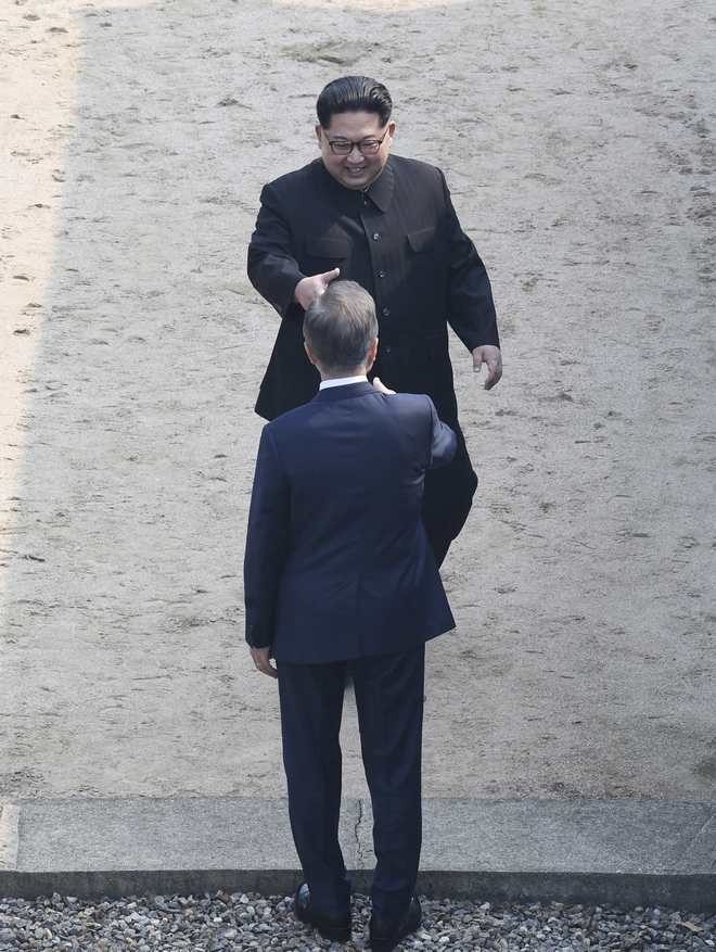 North Korean leader Kim Jong Un, top, prepares to shake hands with South Korean President Moon Jae-in at the border village of Panmunjom in Demilitarized Zone Friday, April 27, 2018. Their discussions will be expected to focus on whether the North can be persuaded to give up its nuclear bombs. (Korea Summit Press Pool via AP)