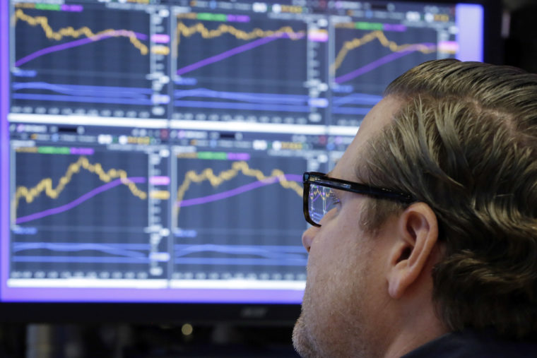 FILE - In this Monday, Dec. 4, 2017, file photo, specialist Gregg Maloney works at his post on the floor of the New York Stock Exchange. The stock market had a banner year overall, but there were plenty of big winners, and big losers, among individual U.S. companies in 2017. (AP Photo/Richard Drew, File)