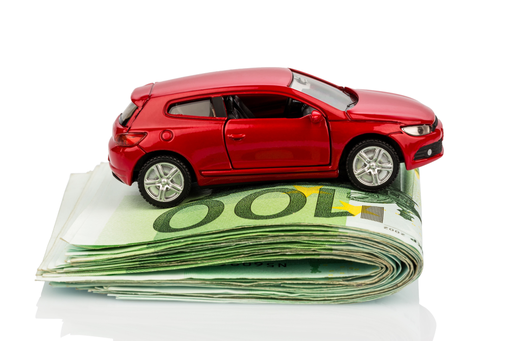 a car standing on euro bills. cost of buying a car, gasoline, car insurance and other costs