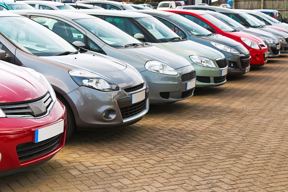 Line up of various types of used cars for sale on a motor dealers forecourt all marques removed