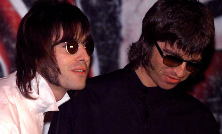 FILE PHOTO: Liam and Noel (R) Gallagher, of the British rock band Oasis, wait for the start of a news conference at a pub in London, Britain August 25.  REUTERS/Dylan Martinez/File Photo