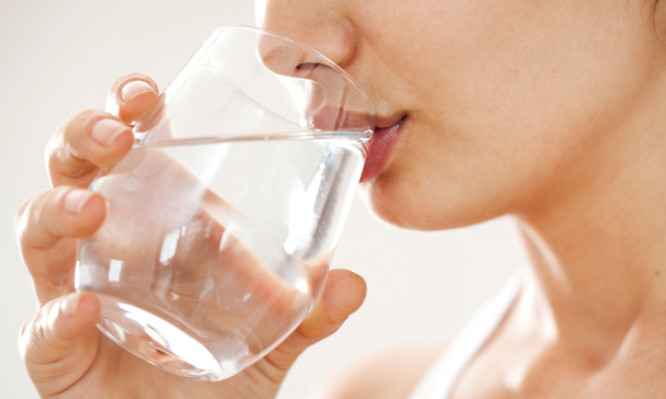 Young woman drinking  glass of water