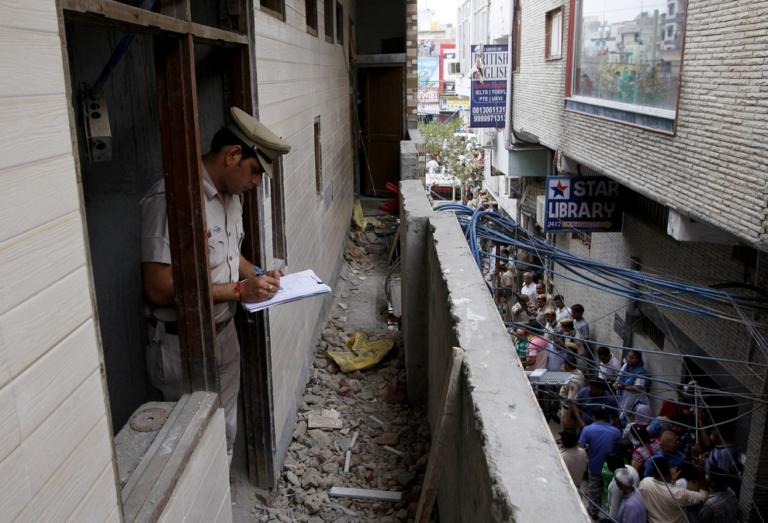 A policeman writes notes in the house where the bodies of eleven members of a family were found dead in Burari, in New Delhi, India, July 1, 2018. REUTERS/Stringer