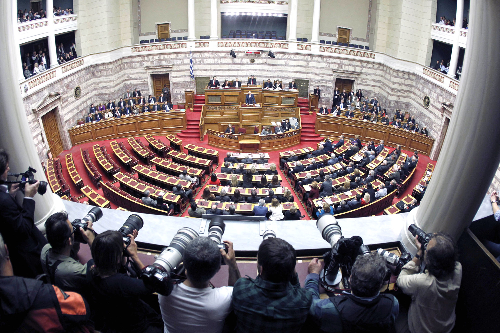 Greek Prime Minister George Papandreou delivers a speech as photographers cover the confidence vote meeting at the parliament in Athens, on Friday, Nov. 4, 2011. Greece's ruling Socialists were in open revolt against their own prime minister ahead of a confidence vote Friday, in a political free-for-all over a new European plan to keep the deeply indebted country afloat. (AP Photo/Petros Giannakouris)