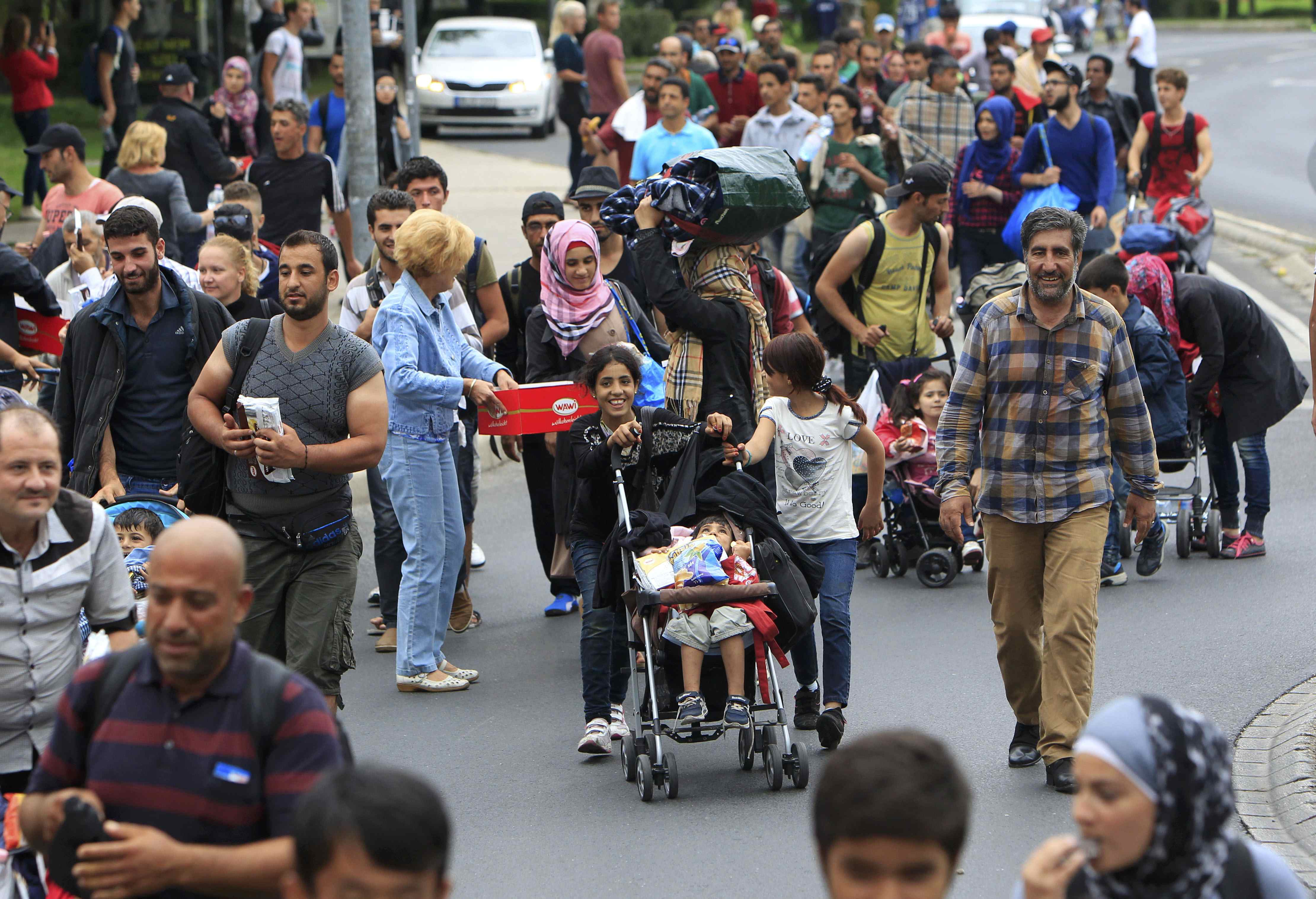 Migrants walk along a road to the Austrian border near the town of Budaors, outside Budapest, Hungary, September 5, 2015.  Austria and Germany threw open their borders to thousands of exhausted migrants on Saturday, bussed to the Hungarian border by a right-wing government that had tried to stop them but was overwhelmed by the sheer numbers reaching Europe's frontiers.        REUTERS/Bernadett Szabo