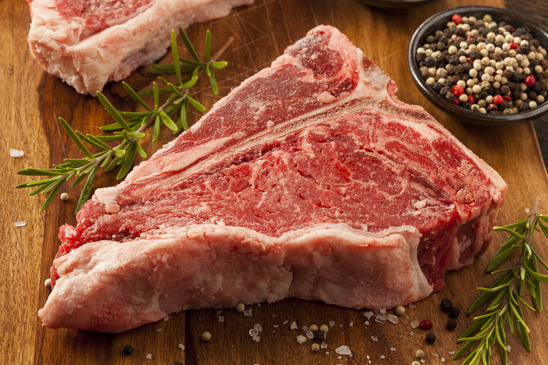 Thick Raw T-Bone Steak with Seasoning and Rosemary