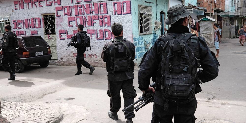 BOPE police special forces patrol an alley of the Mare shantytown complex in Rio de Janeiro, Brazil, on May 4, 2015. Rio's police is on the econd phase of replacing the Brazilian army personnel involved in pacification tasks in the 140,000 inhabitants Mare slum complex, in a process they expect to end by June 30. AFP PHOTO / YASUYOSHI CHIBA