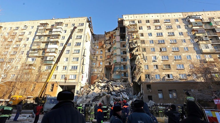 Emergency Situations employees working at the scene of a collapsed apartment building in Magnitogorsk, a city of 400,000 people, about 1,400 kilometers (870 miles) southeast of Moscow, Russia, Monday, Dec. 31, 2018. Russian emergency officials say that at least four people have died after sections of the apartment building collapsed after an apparent gas explosion in the Ural Mountains region. (AP Photo/Maxim Shmakov)