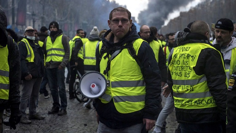 epa07187430 Protesters wearing yellow vests, as a symbol of French driver's and citizen's protest against higher fuel prices, during clashes with police on the Champs Elysee as part of a nationwide protest in Paris, France, 24 November 2018. The so-called 'gilets jaunes' (yellow vests) protest movement, which has reportedly no political affiliation, is protesting over fuel prices.  EPA/Julien de Rosa