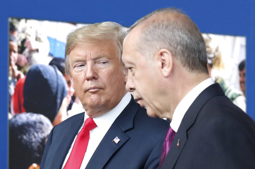 FILE - In this July 11, 2018 file photo, President Donald Trump, left, talks to Turkish President Recep Tayyip Erdogan as they tour the new NATO headquarters in Brussels, Belgium.  Trump’s decision to withdraw American troops from Syria was made hastily, without consulting his national security team or allies, and over the strong objections of virtually everyone involved in the fight against the Islamic State, according to U.S. officials. Trump stunned his Cabinet, lawmakers and much of the world with the move that triggered Defense Secretary Jim Mattis’ resignation by rejecting the advice of his top aides and agreeing to the pull-out in a phone call with Turkish President Recep Tayyip Erdogan last week, two officials briefed on the matter said. (Tatyana Zenkovich/pool photo via AP)