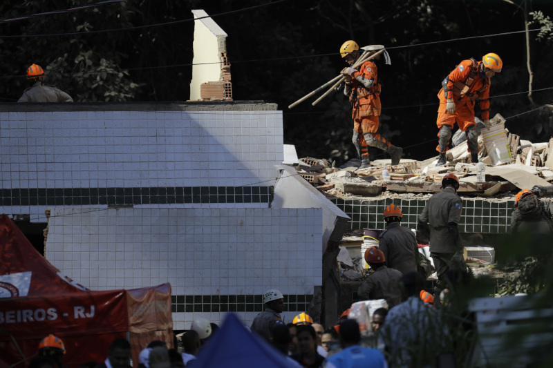 Firefighters search for survivors in the rubble of two buildings that collapsed in the Muzema neighborhood, in Rio de Janeiro, Brazil, Friday, April 12, 2019. The collapse came in a western part of the city that was particularly hard hit by heavy rains this week that caused massive flooding. (AP Photo/Leo Correa)