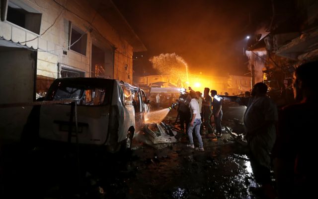 People try to extinguish a fire at the site of a car bomb blast in Azaz, Syria June 2, 2019. REUTERS/Khalil Ashawi