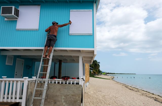 A man boards up a window of a beach house in the tourist zone of El Combate as Tropical Storm Dorian approaches in Cabo Rojo, Puerto Rico August 27, 2019.  REUTERS/Ricardo Arduengo