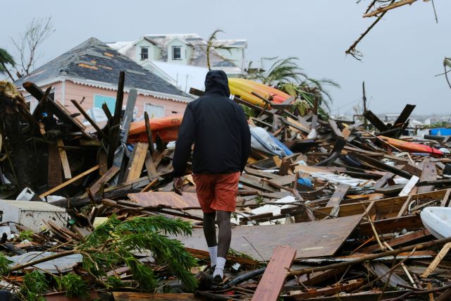 FILE PHOTO: A man walks through the rubble in the aftermath of Hurricane Dorian on the Great Abaco island town of Marsh Harbour, Bahamas, September 2, 2019. REUTERS/Dante Carrer/File Photo