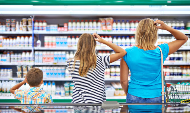 Mother and children are choosing dairy products in shop