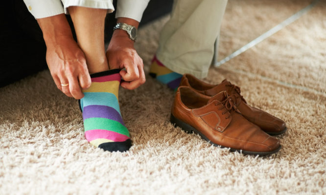 Man putting on colourful socks