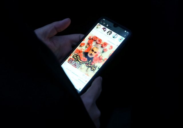 An Iranian woman shows a photo of the late Iranian Major-General Qassem Soleimani, during a protest against the assassination of Soleimani, head of the elite Quds Force, and Iraqi militia commander Abu Mahdi al-Muhandis, who were killed in an air strike at Baghdad airport, in front of UN office in Tehran, Iran January 3, 2020. WANA (West Asia News Agency)/Nazanin Tabatabaee via REUTERS ATTENTION EDITORS - THIS IMAGE HAS BEEN SUPPLIED BY A THIRD PARTY.