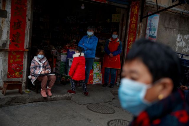 People wear protective masks in an old neighbourhood of Jiujiang, Jiangxi province, China, as the country is hit by an outbreak of novel coronavirus.  February 2, 2020.  REUTERS/Thomas Peter