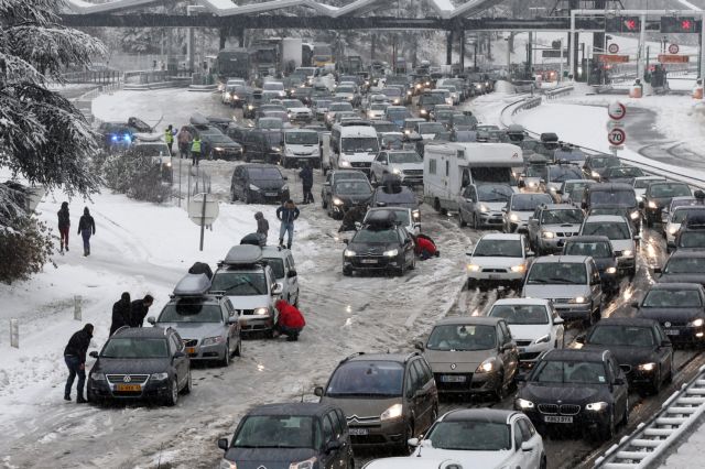 epa04541211 Drivers park  to put on snow chains in the middle of a large traffic congestion in the Savoy region, France, 27 December 2014. A reported 15,000 drivers were stranded and had to be rescued during the night or were blocked on the roads due to the heavy snowfall hitting the French Alps region  EPA/Muscio Sylvain FRANCE AND BELGIUM OUT