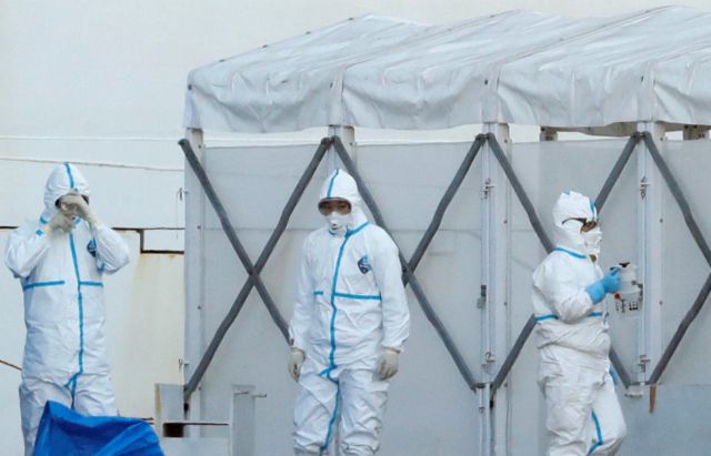 Officers wearing protective suits stand near the cruise ship Diamond Princess, as they prepare to transfer passengers tested positive for the novel coronavirus, at Daikoku Pier Cruise Terminal in Yokohama, south of Tokyo, Japan February 10, 2020. REUTERS/Kim Kyung-Hoon