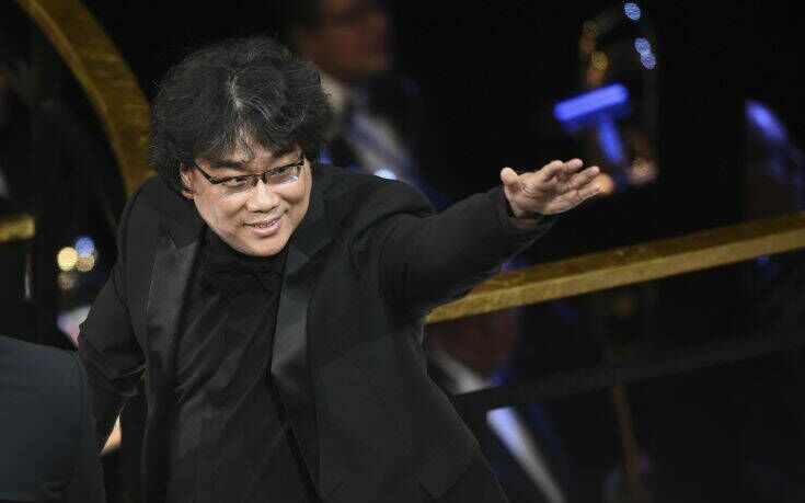 Bong Joon Ho gestures from the audience before accepting the award for best original screenplay for "Parasite" at the Oscars on Sunday, Feb. 9, 2020, at the Dolby Theatre in Los Angeles. (AP Photo/Chris Pizzello)