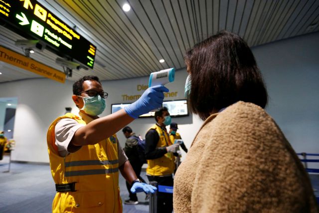 Health Quarantine officer checks people with a thermal scanner after Indonesia confirmed its first cases of coronavirus disease (COVID-19), in Soekarno Hatta International Airport, in Tangerang near Jakarta, Indonesia, March 6, 2020. REUTERS/Ajeng Dinar Ulfiana