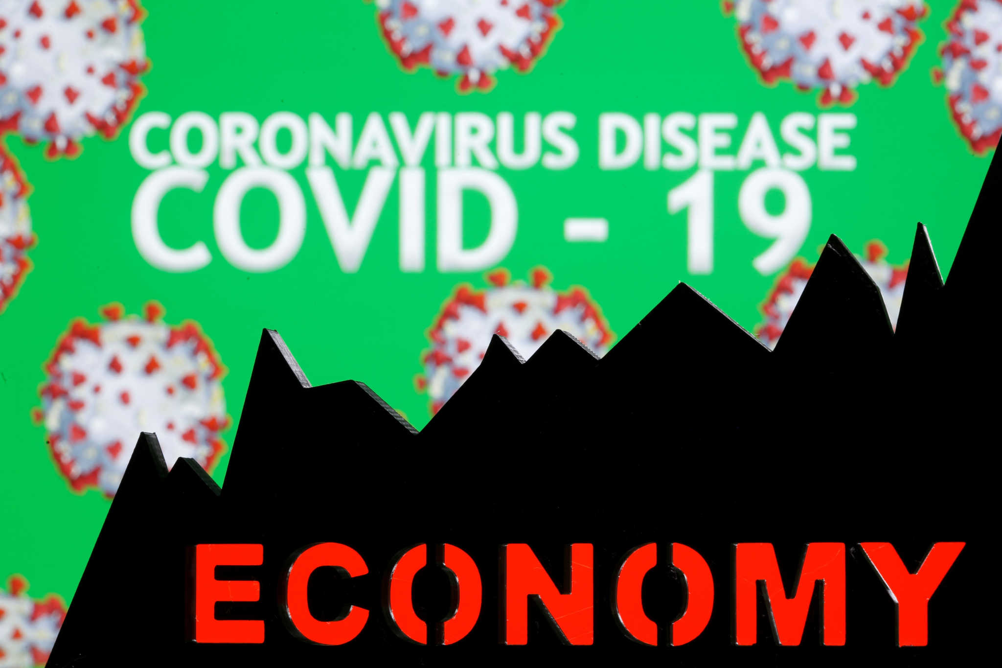 A 3D-printed economy stock graph is seen in front of displayed coronavirus disease (COVID-19) words in this illustration taken March 24, 2020. REUTERS/Dado Ruvic