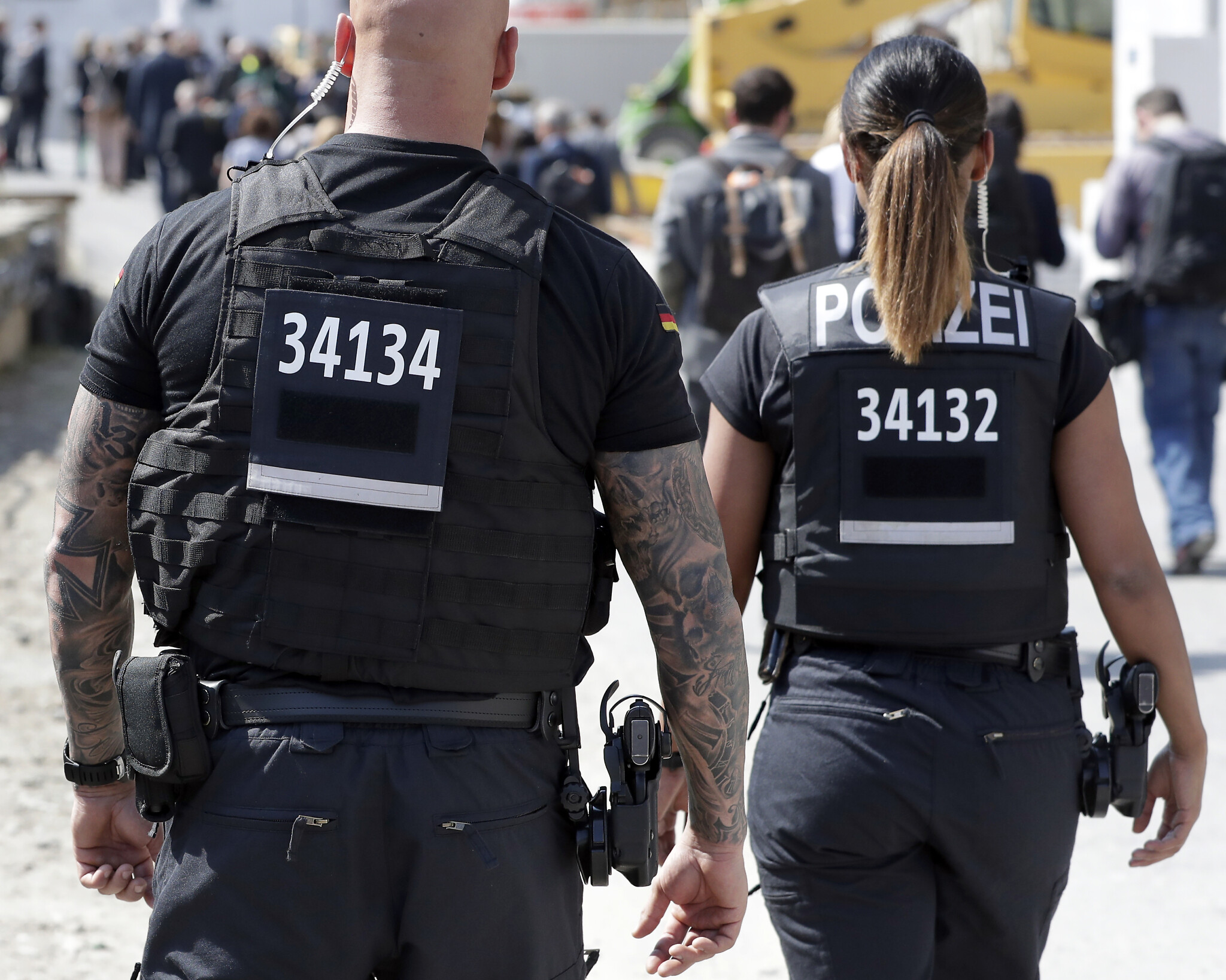 A federal police officer sports a tattoo when guarding the meeting o French President Emmanuel Macron with German Chancellor Angela Merkel at the reconstruction site of the Berlin Palace in Berlin, Germany, Thursday, April 19, 2018. (AP Photo/Michael Sohn)