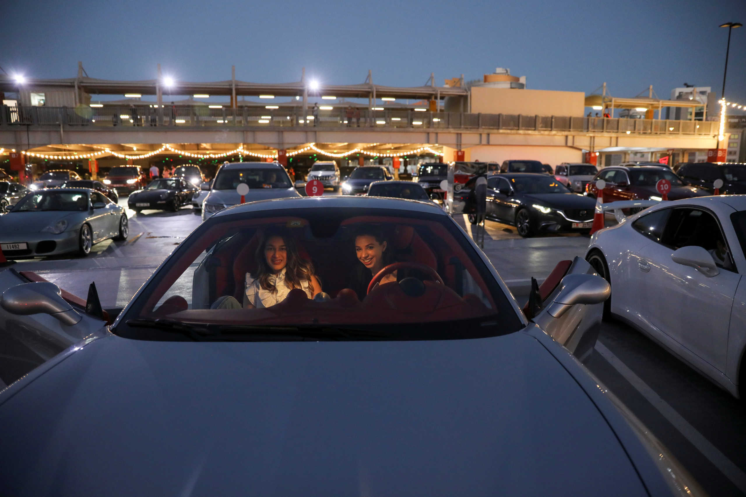 People sit in their cars watching a movie in a drive-in cinema at the Mall of the Emirates, following the outbreak of the coronavirus disease (COVID-19), in Dubai, United Arab Emirates, May 13, 2020. REUTERS/Ahmed Jadallah